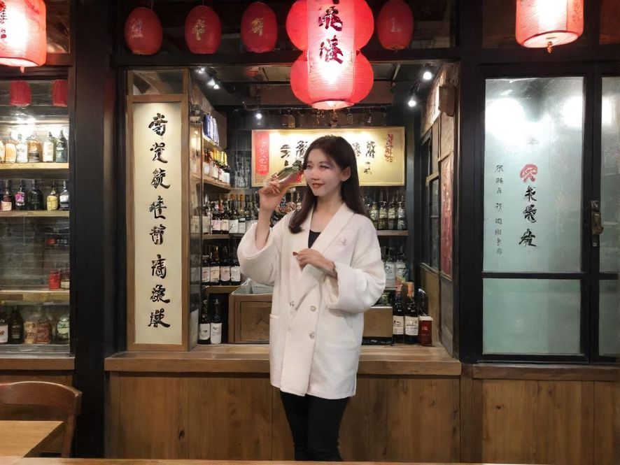 一位气质优雅的女性在奢华酒店大堂中侧面微笑,营造出高端伴游的氛围。
